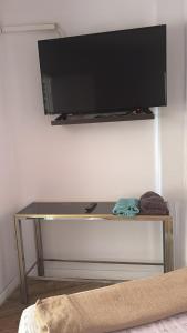 a flat screen tv on top of a table at Ático sin ascensor in Esplugues de Llobregat
