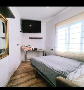a bedroom with a bed and a television on the wall at Ático sin ascensor in Esplugues de Llobregat