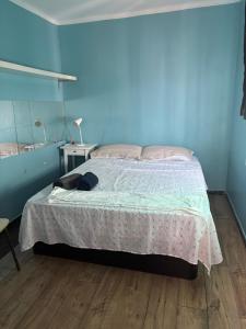 a bedroom with a bed and a blue wall at Ático sin ascensor in Esplugues de Llobregat +8 photos