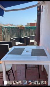 a white table on a patio with chairs and a table at Ático sin ascensor in Esplugues de Llobregat