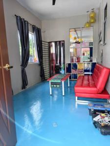 a living room with a red couch and a blue floor at Family Villa - BERA Poolstay 