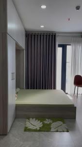 a bedroom with a large bed and a chair at Ocean View Studio in Tuy Hoa in Tuy Hoa
