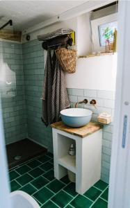 a bathroom with a sink and a shower with green tiles at La Cantina: cosy stylish vaults in Villalfonsina