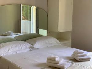 two white towels are sitting on a white bed at B&B Madreperla in Gallipoli