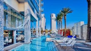 a pool at a hotel with chairs and palm trees at Luxe Condo Free Parking No Resort Fees in Las Vegas