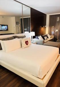 a large white bed in a room with a couch at Luxe Condo Free Parking No Resort Fees in Las Vegas