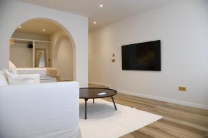 ハベアにあるAmber Apartmentsのテーブルと壁にテレビが置かれたリビングルーム