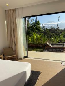 a bedroom with a bed and a large glass window at Julim Aura - Best Agung View in Amed +25 photos