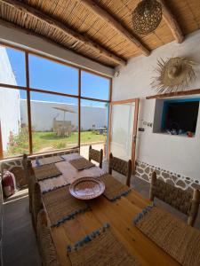 ein Esszimmer mit Tisch und Stühlen und einem großen Fenster in der Unterkunft Octopus house in Wassane