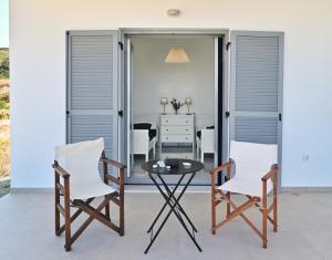 a patio with two chairs and a glass table at Villa Almar in Adamas