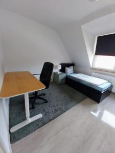 a small room with a desk and a bed at Monteurwohnung - Bertholdstraße 19 in Pforzheim