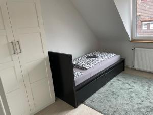 a small bedroom with a bed in the corner at Monteurwohnung - Bertholdstraße 19 in Pforzheim