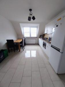 a kitchen with a table and a white refrigerator at Monteurwohnung - Bertholdstraße 19 in Pforzheim