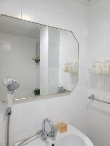 Baño blanco con espejo y lavabo en Feel Stay, en Suwon