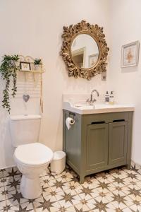 a bathroom with a toilet and a sink and a mirror at The Lodge at Greenbank Farm 