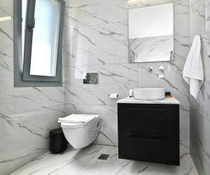 a white bathroom with a toilet and a sink at Villa Almar in Adamas +41 photos