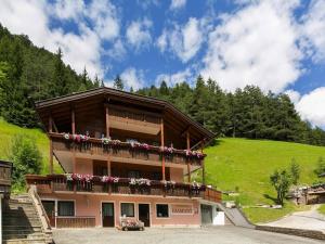 a building with a balcony with flowers on it at Amazing apartment house Diamant with breathtaking view in Santa Cristina in Val Gardena