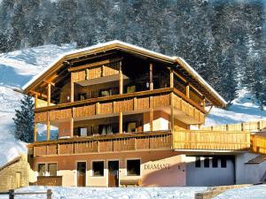 a large building with a balcony in the snow at Amazing apartment house Diamant with breathtaking view in Santa Cristina in Val Gardena