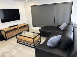 a living room with a couch and a tv at Wine Not Relax in Yzerfontein