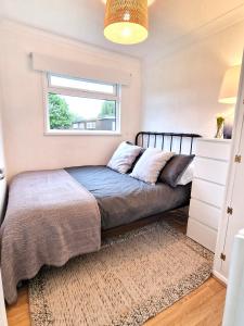 a bedroom with a bed and a window at 93 Broadside Holiday Chalet near Broads & Beaches in Stalham