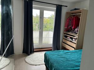 Un dormitorio con una cama y una ventana grande. en Bright, well furnished apartment, en Hillerød