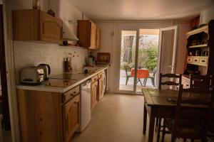 a kitchen with a counter and a table and a door at Gîte "Chante' Relle" in Privas