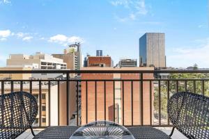 a balcony with two chairs and a view of a city at Perth City Retreat Victoria Ave 1br in Perth +7 photos