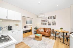 a kitchen and living room with a couch and a table at Perth City Retreat Victoria Ave 1br in Perth