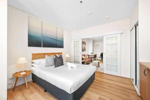 a bedroom with a large bed and a living room at Perth City Retreat Victoria Ave 1br in Perth