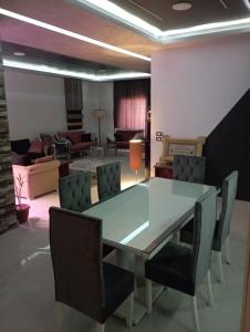 Banī GhālibにあるLuxury apartment with stunning viewsのダイニングルーム(ガラスのテーブル、椅子付)