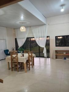 a dining room with a table and chairs and windows at Misiones Apart in Dos de Mayo