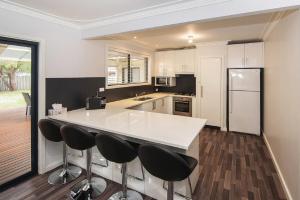 a kitchen with a white counter and black appliances at Haven By the Bay- Short walk to Broadwater beach in Broadwater