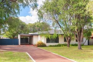 a white house with a driveway and trees at Haven By the Bay- Short walk to Broadwater beach in Broadwater