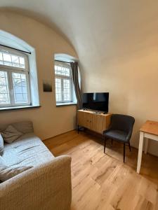 a living room with a couch and a television at Das Lehmgewölbe im historischen Haus in Marktbreit +5 photos