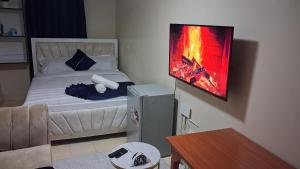a room with a bed with a fire painting on the wall at Utawala studio apartment in Nairobi