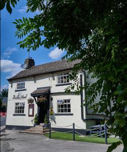 a white building with a gate in front of it at Bulls Head - Holymoorside in Chesterfield