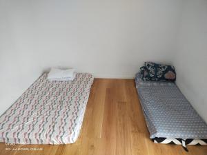 two beds in a room with a wooden floor at Nordic Sleep Spot in Glostrup