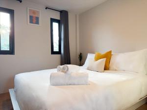 a bedroom with a large white bed with towels on it at Summer House Fisherman's Village in Bophut  +4 photos