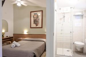 a bedroom with a bed and a toilet and a shower at Hotel Itta in Caorle +47 photos