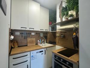 Una cocina con gabinetes blancos y un fregadero. en The Master and Margarita Centre, en Burgas