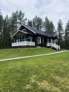 a house with a large yard in front of it at Villa Ihanus 100 m2 ja rantasauna järven rannalla in Kuusamo