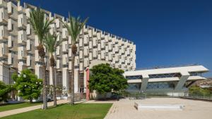 a building with palm trees in front of it at King Solomon Hotel Tiberias in Tiberias