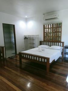 a bedroom with a large bed with white sheets at Puerto Galera Hilltop Guesthouse -Tropical Retreat in Puerto Galera