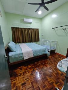 a bedroom with a bed and a ceiling fan at Homestay Klang in Klang