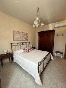 Un dormitorio con una cama y una lámpara de araña. en La casina di Tata, en Terricciola