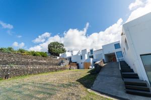 a building with a stone wall next to a sidewalk at Oceanside Village 4 in Lagoa