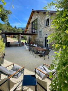 a patio with chairs and a table and a building at Retraites & Séminaires, Spa, La Ressource Malix 19 personnes in Tenay
