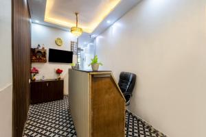 a hallway with a desk and a tv in a room at Hotel Mannat Green Near Naraina Vihar Metro Station in New Delhi