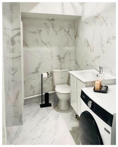 a white bathroom with a toilet and a sink at Beau 3P à 20m du métro et 20 min du cœur de Paris in Les Lilas