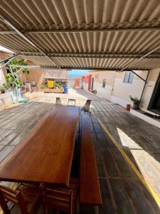 una gran mesa de madera con sillas en el patio en Chalé 2 novo mel, en Areia Branca